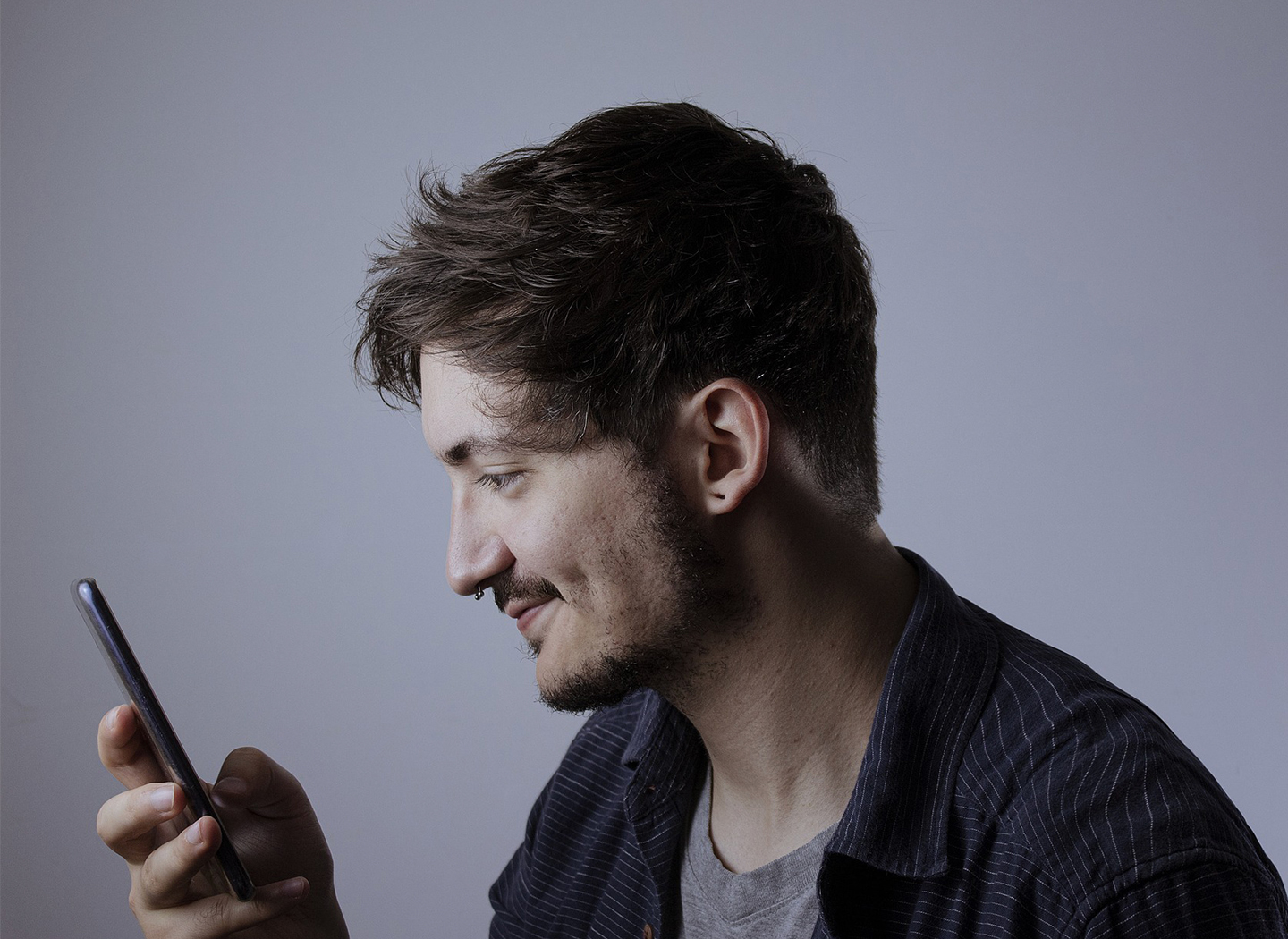 Ein Mann blickt auf sein Smartphone – Sinnbild für digitale Vernetzung